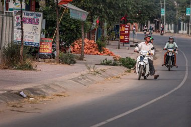 304.2015, Phan Thiet, Vietnam. Yerel Vietnamlı ulusal bir araçla yolda motosiklet sürüyor..