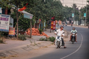 304.2015, Phan Thiet, Vietnam. Yerel Vietnamlı ulusal bir araçla yolda motosiklet sürüyor..