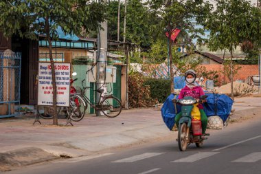 304.2015, Phan Thiet, Vietnam. Yerel Vietnamlı ulusal bir araçla yolda motosiklet sürüyor..