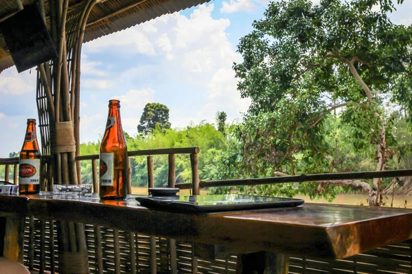 304.2015, Phan Thiet, Vietnam. Nehir kıyısındaki bambu bir çardakta masanın üzerinde bir şişe Vietnam birası..