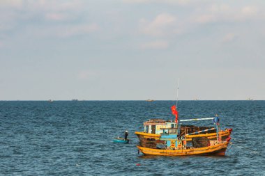 01.05.2015, Phan Thiet, Vietnam. Parlak renkli balıkçı teknesi ufuk çizgisinde kıyı boyunca yol alıyor..