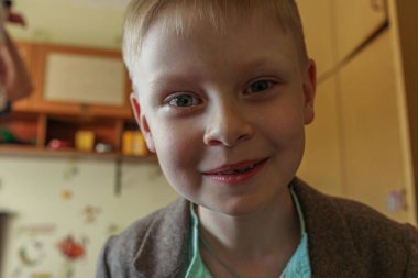 Kameraya bakan küçük sevimli bir çocuğun portresi. Komik Çocuklar Evde.