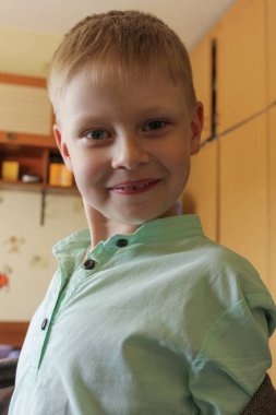 Kameraya bakan küçük sevimli bir çocuğun portresi. Komik Çocuklar Evde.