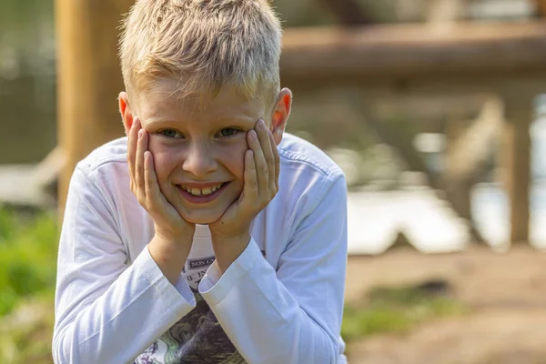 Blondharige Jongen Gekleed Een Witte Sweater Blauwe Jeans Zit Een — Stockfoto