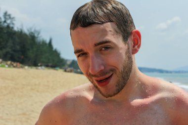 Genç, yakışıklı, sakallı bir adam denizden sahile yeni çıkmıştı. Asya 'yı dolaş..