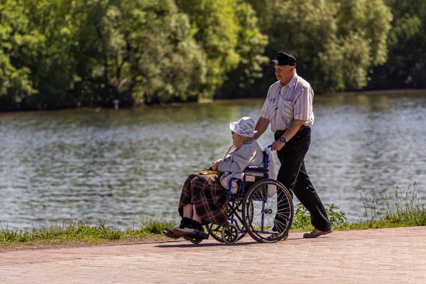 2018 Moscú Rusia Anciano Está Rodando Una Anciana Sentada Una —  Fotos de Stock