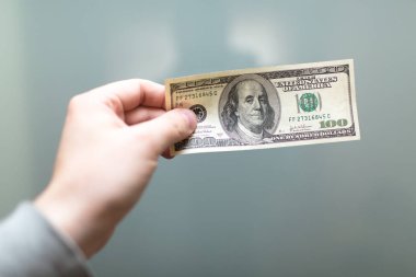 yüz dolar tutan el
