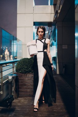 Genç ve güzel kadın siyah beyaz elbise ve çiçekler