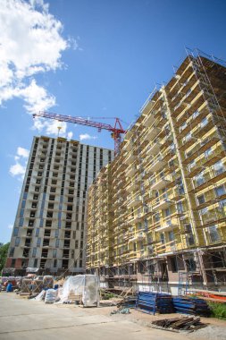 Mavi gökyüzüne karşı vinç ve inşaat alanı