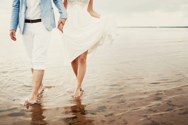 男性と女性歩いて海岸へ 足閉じるし 表面を水 — ストック写真