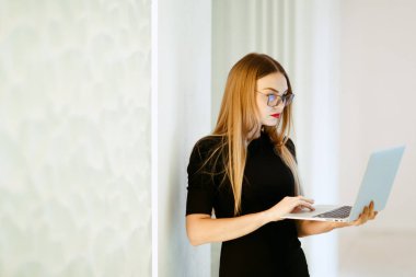 Siyah elbiseli iş kadını ile laptop beyaz ofis arka planda