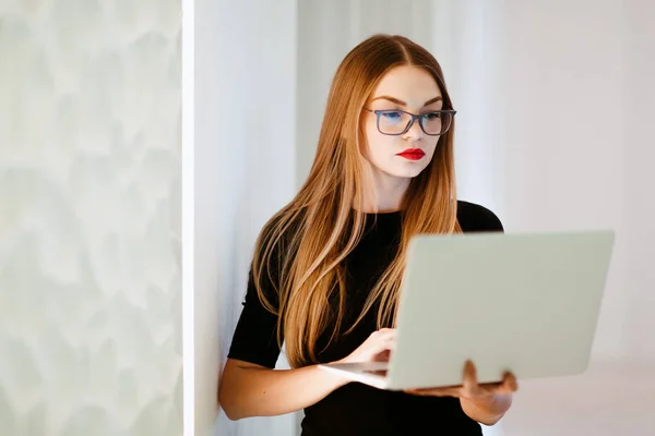 Business woman with notebook in black dress in white office background