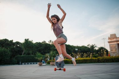 Sportif kadın parkta longboard sürme