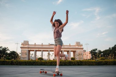 Sportif kadın parkta longboard sürme