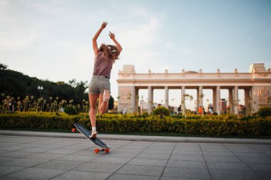 Sportif kadın parkta longboard sürme