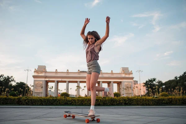 Sportif kadın parkta longboard sürme
