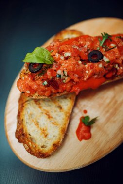 İtalyan meze Bruschetta domates, somon ve baget ahşap plaka üzerinde biber ile.