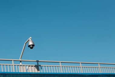 Mavi gökyüzü arka planındaki güvenlik kamerası