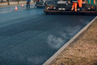 Asfalt kaldırım. Paver makinesi ve yol silindiri. Yeni yol yapımı.