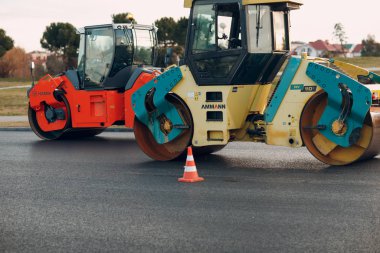 Asfalt kaldırım. Paver makinesi ve yol silindiri. Yeni yol yapımı.