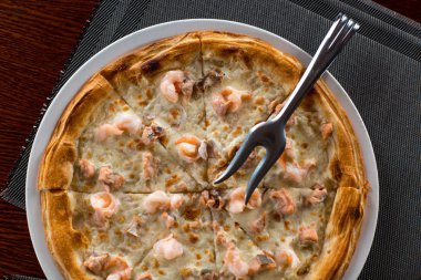 Somonlu pizza ve karides. Masanın üstünde.