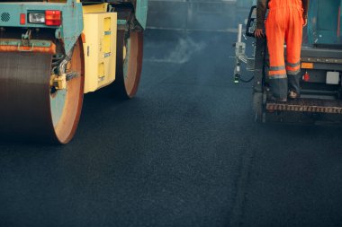 Asfalt kaldırım. Paver makinesi ve yol silindiri. Yeni yol yapımı.