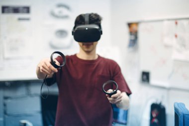Sanal gerçeklik gözlüklü genç adam, joystick 'li VR gözlükler.