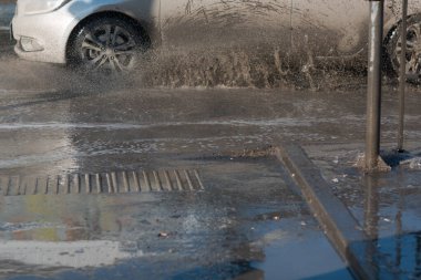 Araç, eriyen kardan oluşan su birikintilerinin içinden geçiyor. Tekerleklerin altından püskürt.