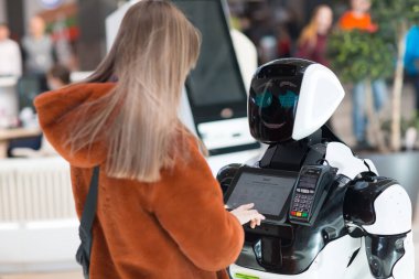 Mağazadaki genç bayan alışverişçi ve robot danışmanı.