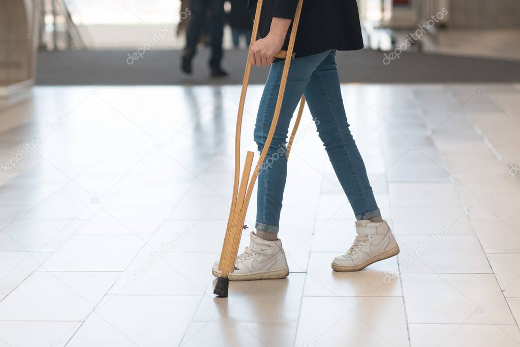 Girl in jeans with crutches. No face.