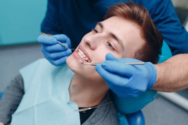 Diş hekimliği. Dişçi ve hasta. Diş sağlığı kliniği. Dişler kontrol ediliyor.