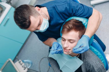 Diş hekimliği. Dişçi ve hasta. Diş sağlığı kliniği. Dişler kontrol ediliyor.