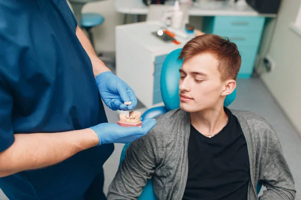 歯科医は患者にインプラントを示します 歯科医院 — ストック写真