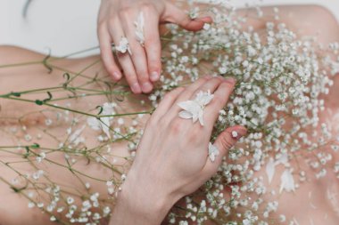 Göğsünde küçük beyaz çiçekler olan genç bir erkek model. Güzel portre..