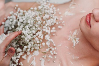 Göğsünde küçük beyaz çiçekler olan genç bir erkek model. Güzel portre..