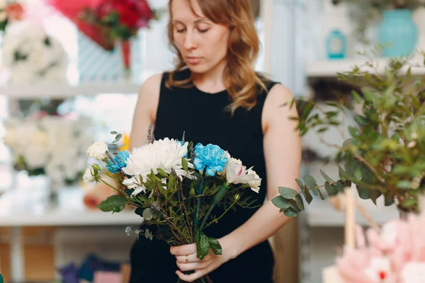 Florist makes a bouquet in a flower boutique