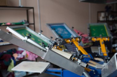 İpek ekran yazdırma. Serigrafi. Renkli boyalar ve kumaş. Atlıkarınca makinesi.
