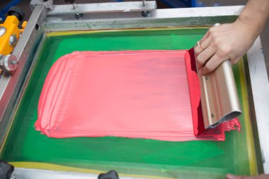 İpek ekran yazdırma. Serigrafi. Renkli boyalar ve kumaş. Plastisol boya ve cam sileceği..