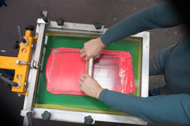 İpek ekran yazdırma. Serigrafi. Renkli boyalar ve kumaş. Plastisol boya ve cam sileceği..