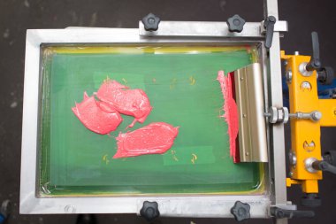 İpek ekran yazdırma. Serigrafi. Renkli boyalar ve kumaş.