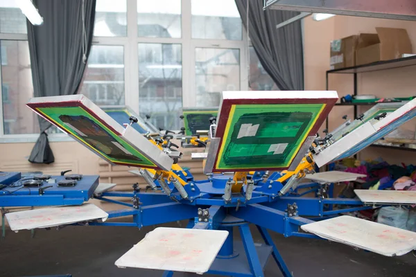 İpek ekran yazdırma. Serigrafi. Renkli boyalar ve kumaş. Atlıkarınca makinesi.