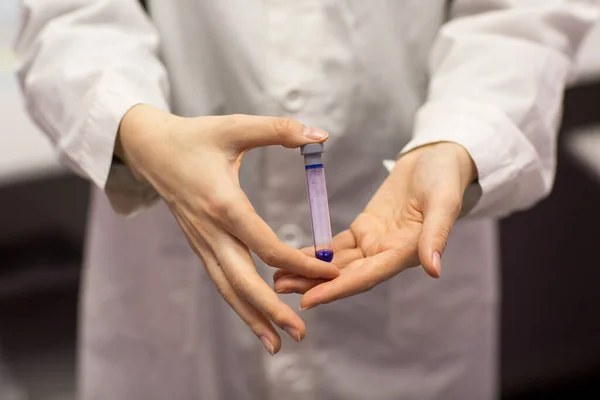 Woman lab technician holding test tube