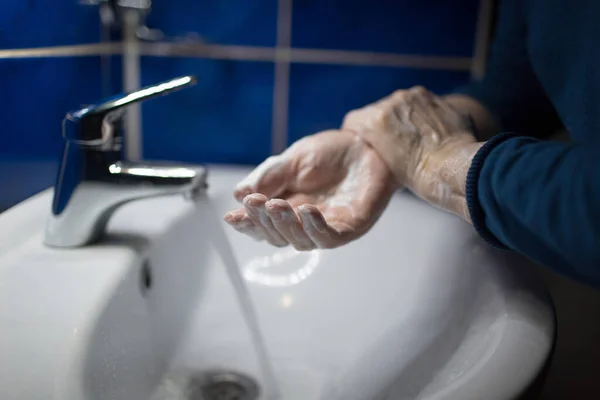 Woman washes hands with soap under water tap. Coronavirus prevention and washing. Pandemic COVID-19 Hygiene Rules.