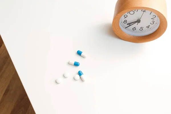 Reloj Despertador Píldoras Blancas Azules Sobre Fondo Mesa Blanco — Foto de Stock