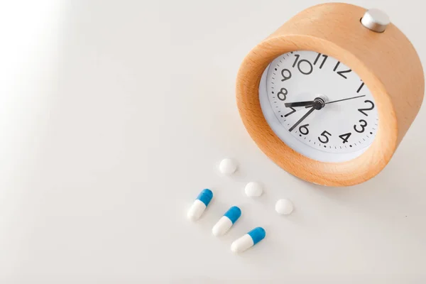 Reloj Despertador Píldoras Blancas Azules Sobre Fondo Mesa Blanco — Foto de Stock