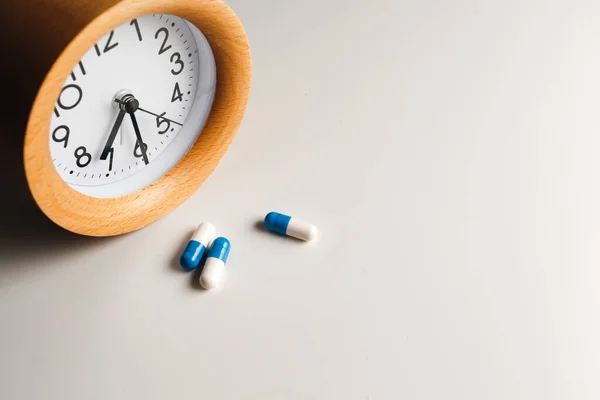 Reloj Despertador Píldoras Blancas Sobre Fondo Mesa Blanco — Foto de Stock