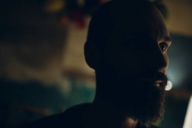 Arka ışıklandırılmış sakallı yetişkin profili portresi