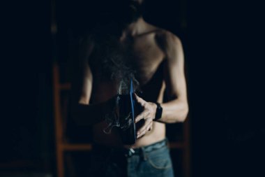 Adam elinde yanan bir kitap tutuyor..