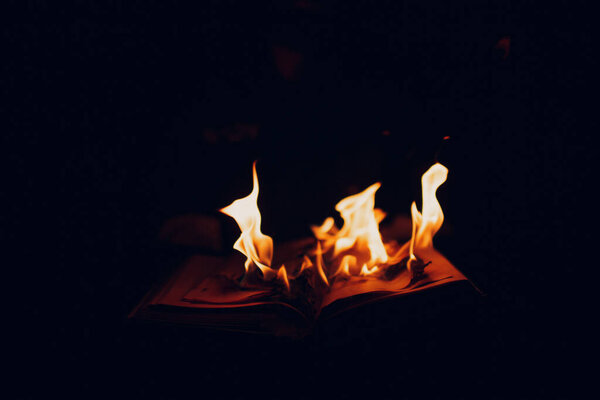 Book burns on dark background