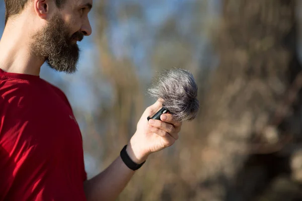 Pria Berjenggot Memegang Mikrofon Dengan Perlindungan Suara Angin — Stok Foto